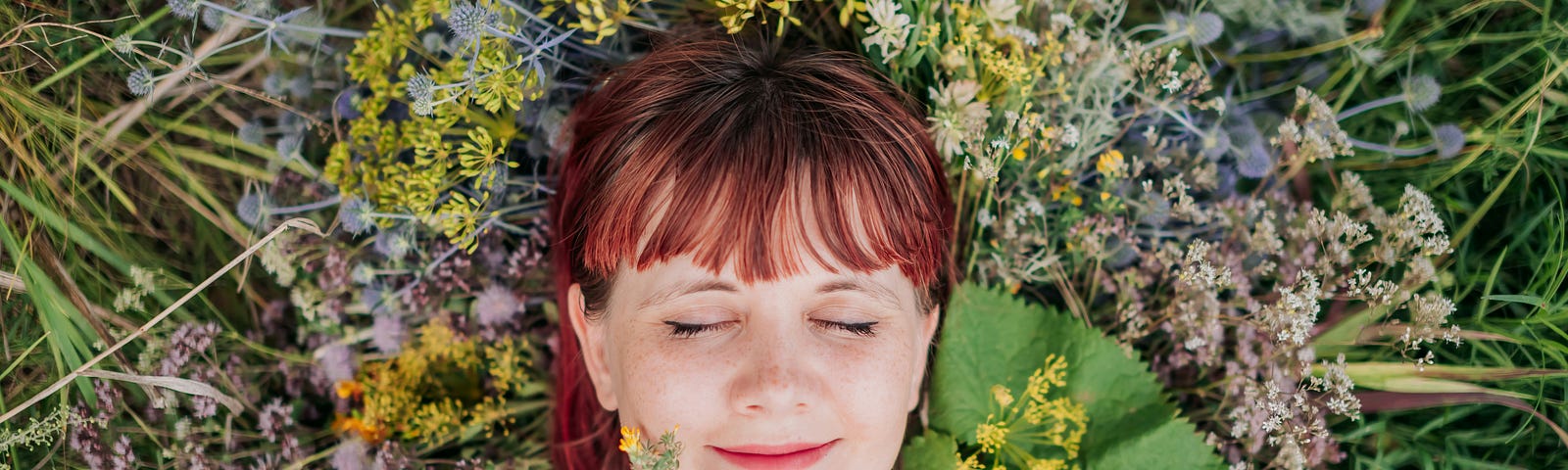 A woman relaxes peacefully surrounded by flowers